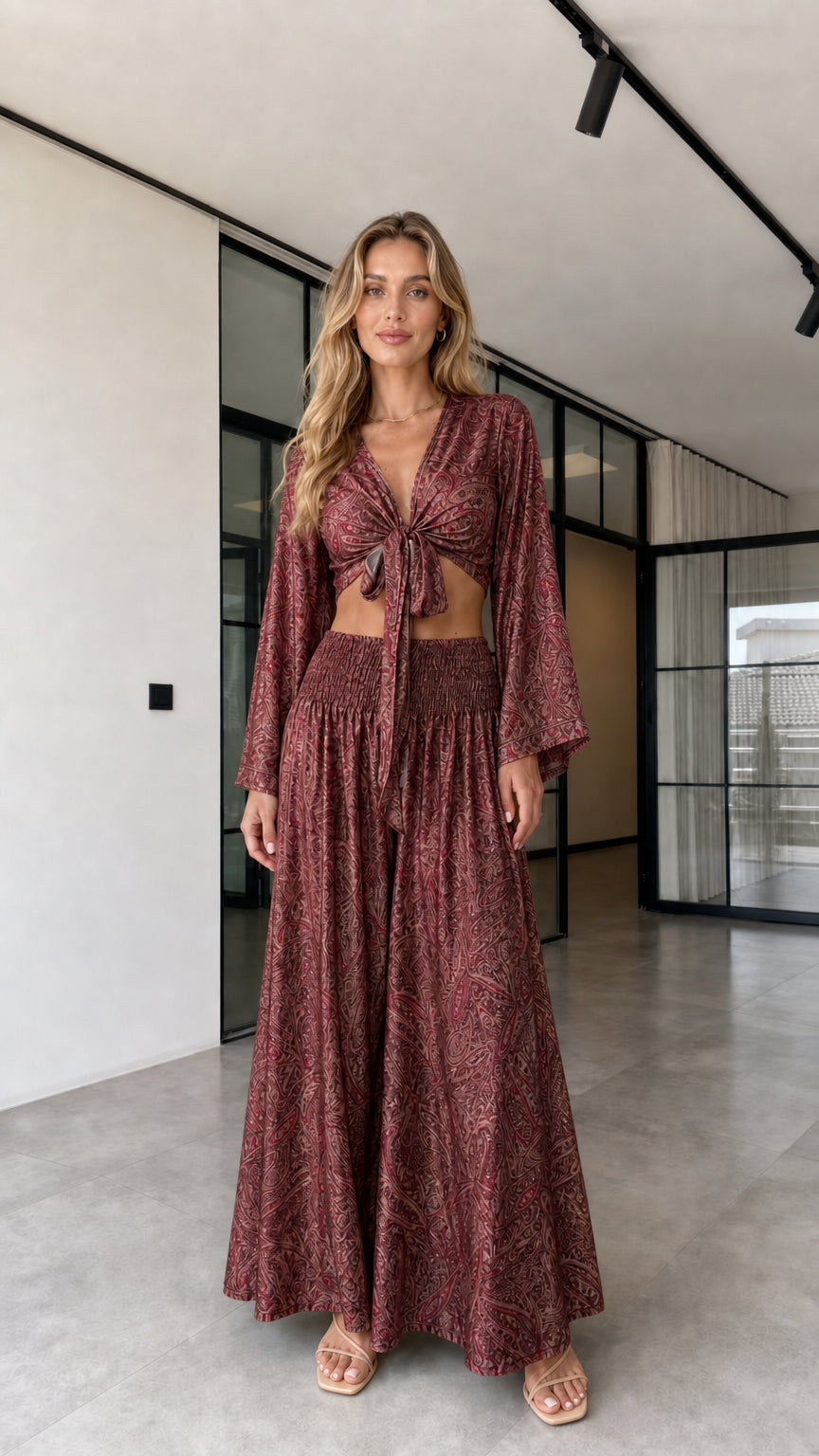 Model wearing the burgundy paisley-inspired tie-front crop top and wide-leg pants set