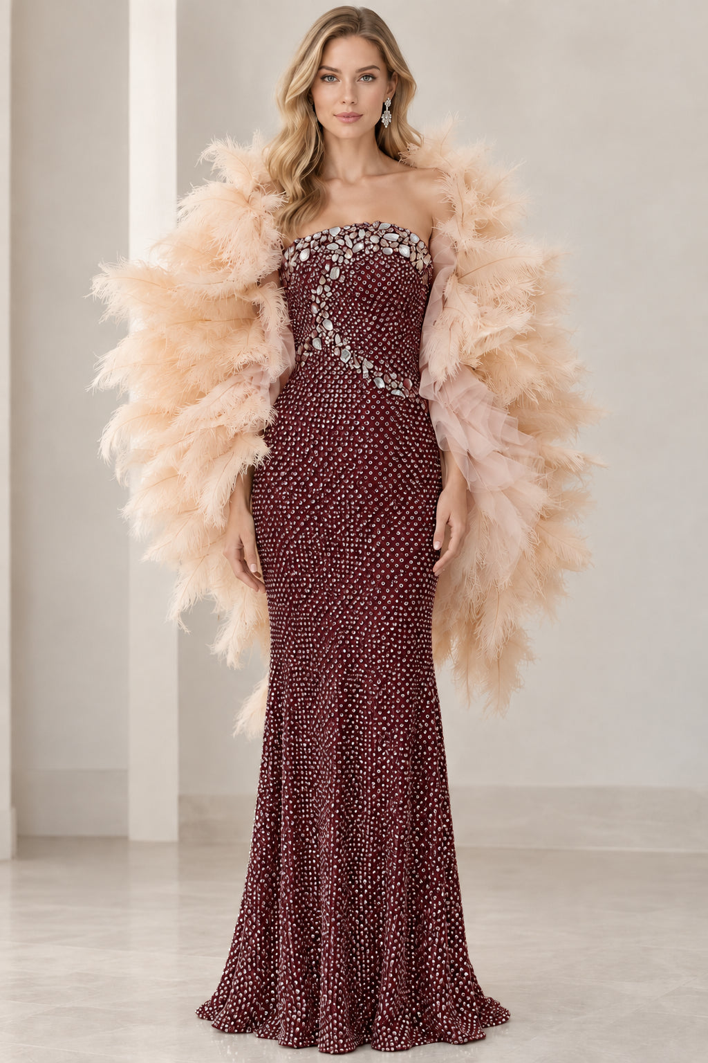Front view of rich burgundy red strapless embellished gown with feather shawl