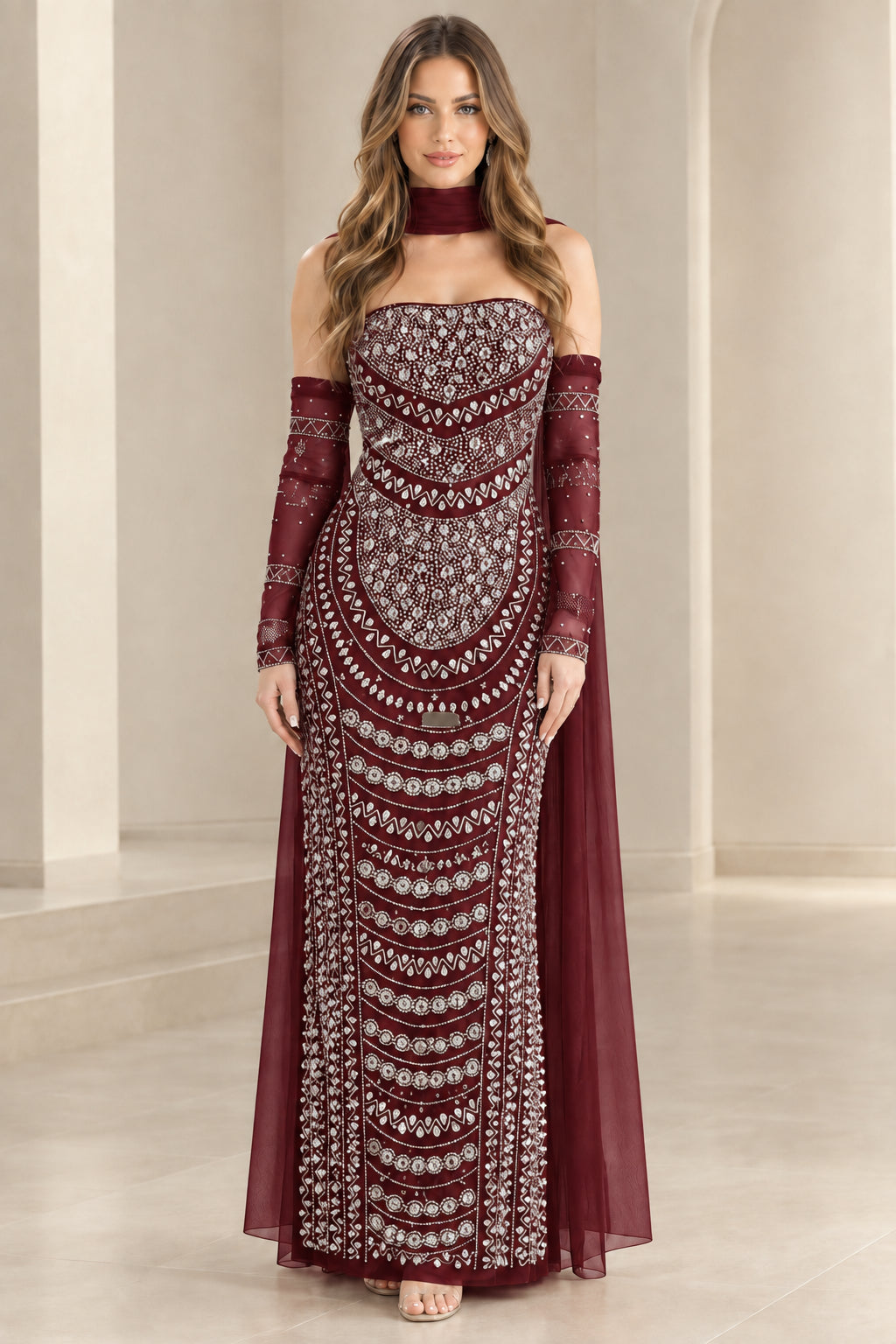 Model wearing burgundy wine embellished formal evening gown with sheer cape sleeves
