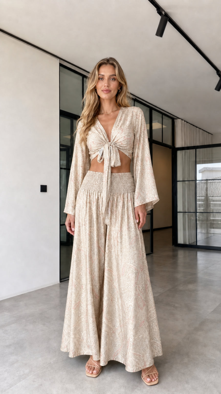 Model wearing the cream paisley-inspired tie-front crop top and wide-leg pants set